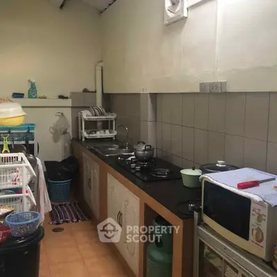 Compact kitchen with basic appliances and storage, ideal for small spaces.
