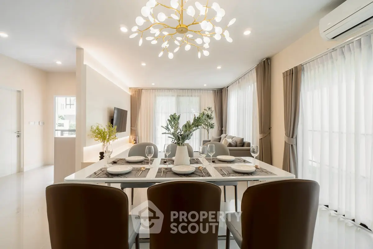 Luxurious open-plan living and dining area with elegant decor and modern lighting