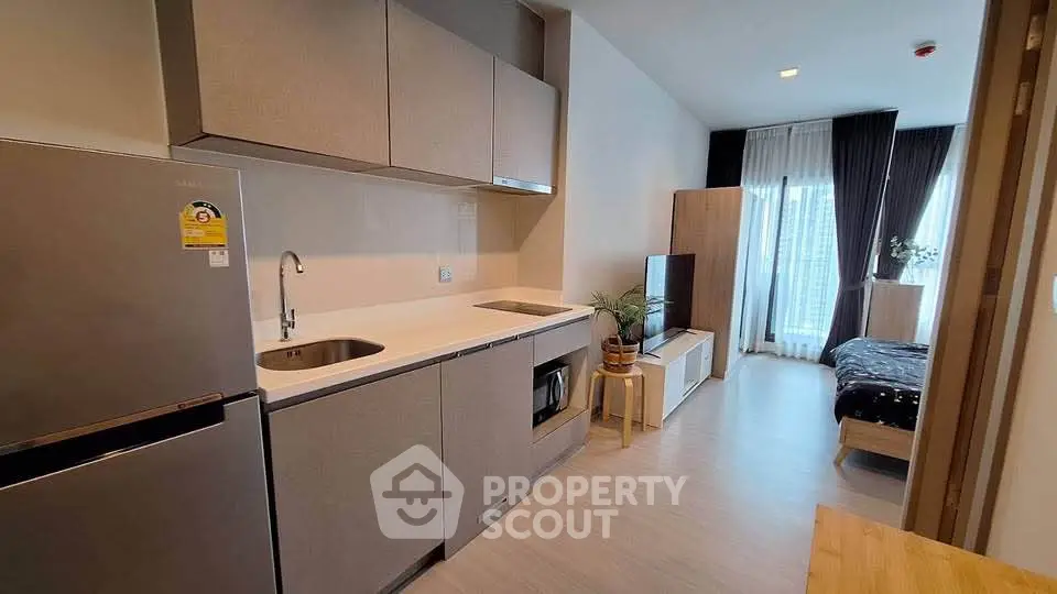 Modern studio apartment with sleek kitchen and cozy bedroom area