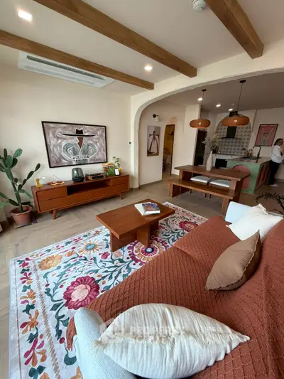 Charming living room with stylish decor, featuring a cozy sofa, vibrant rug, and elegant wooden furniture.