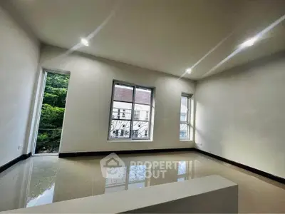 Spacious empty room with large windows and glossy tiled floor, ideal for customization.