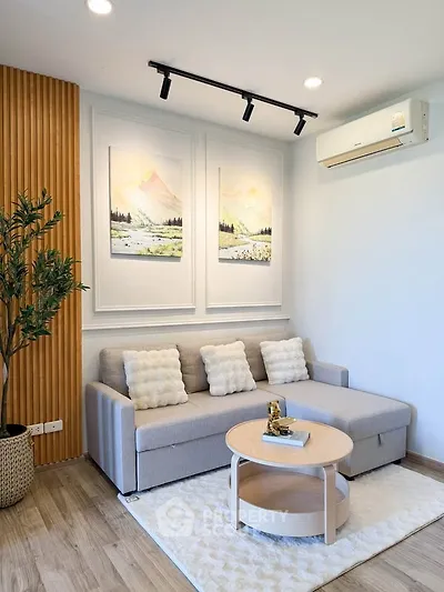 Modern living room with stylish decor, featuring a cozy sofa, elegant wall art, and a sleek air conditioning unit.