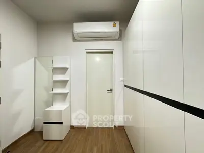 Modern minimalist bedroom with sleek white furniture and wooden flooring