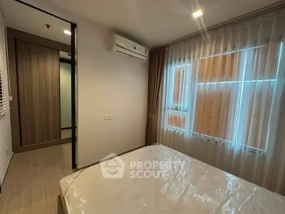 Modern bedroom with large window and air conditioning in a stylish apartment.