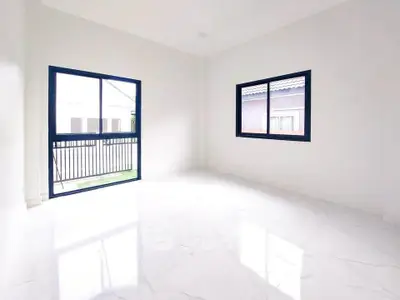 Bright empty room with large windows and marble flooring in modern home.