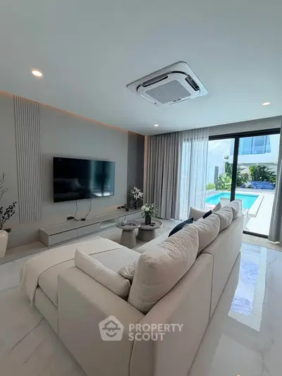 Luxurious living room with pool view, modern decor, and elegant furnishings in a contemporary home.