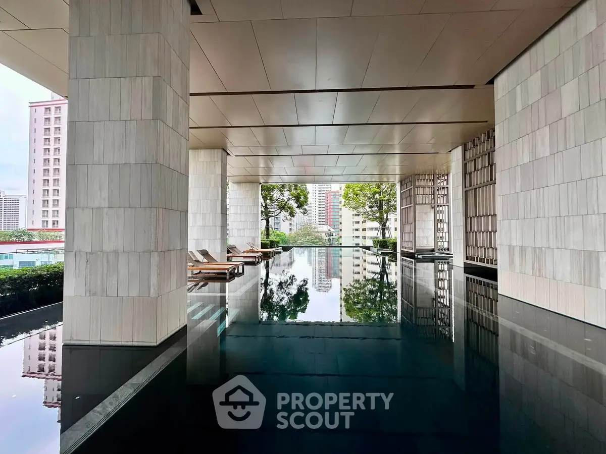 Luxurious indoor pool area with modern design and city views, perfect for relaxation and leisure.