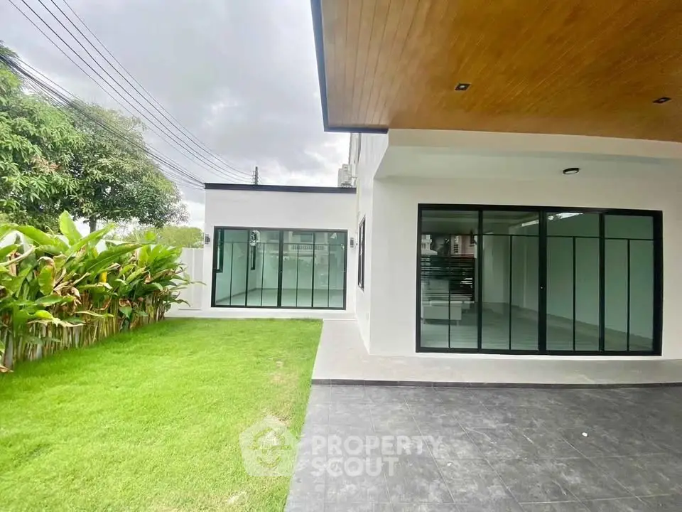 Modern house exterior with lush garden and sleek glass doors