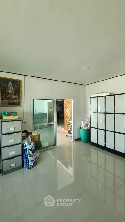 Spacious office room with lockers and sliding glass door, ideal for storage or workspace.