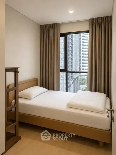 Cozy bedroom with city view, featuring a comfortable bed and modern decor, perfect for urban living.