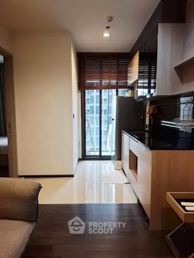 Modern kitchen with sleek cabinetry and large window offering city view