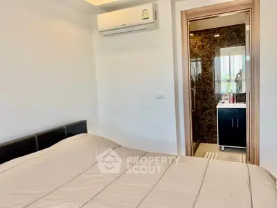 Modern bedroom with ensuite bathroom and air conditioning in stylish apartment.