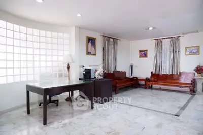 Spacious living room with elegant marble flooring and classic wooden furniture.