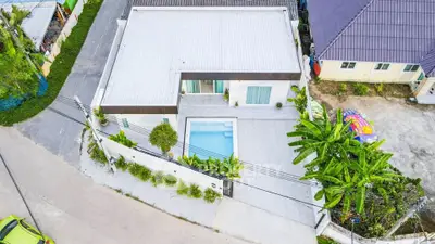 Modern corner unit house with private pool and lush greenery, offering privacy and contemporary design.