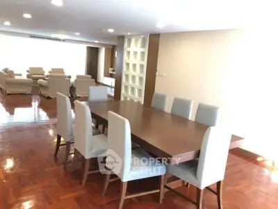 Spacious dining area with elegant wooden flooring and modern furniture in a luxurious apartment.