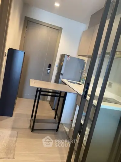 Modern compact kitchen with sleek design and integrated appliances in a stylish apartment.