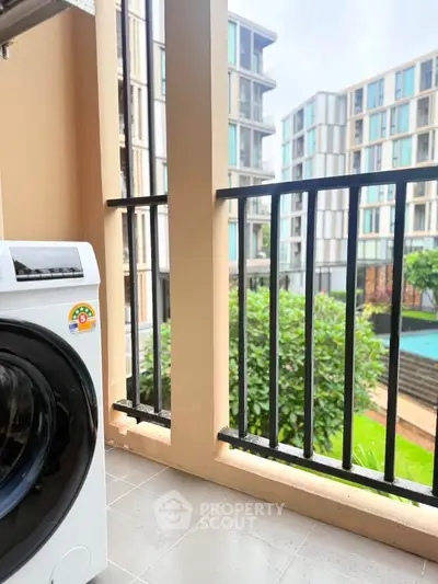 Modern apartment balcony with washing machine and pool view, perfect for urban living.