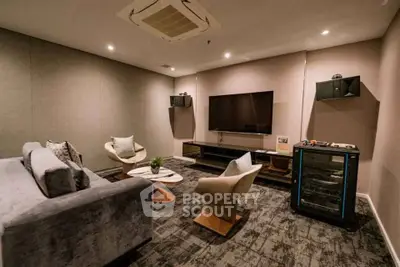 Luxurious living room with modern furniture and large TV, perfect for relaxation and entertainment.