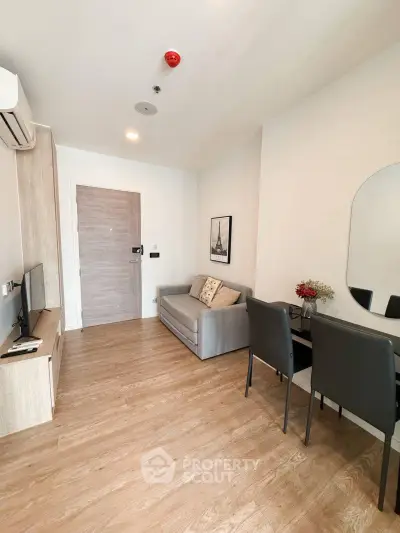 Modern living room with sleek furniture and wooden flooring in a cozy apartment.