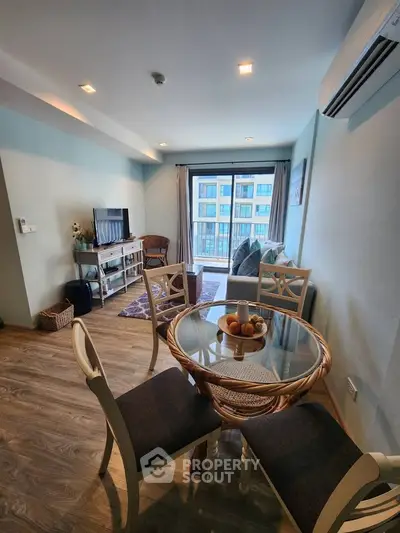 Charming living room with dining area, featuring modern decor and large windows for natural light.