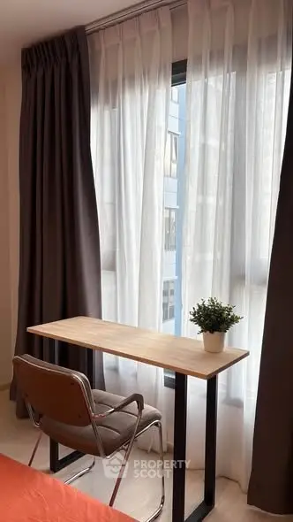 Cozy study nook with modern desk and chair by a window with city view.