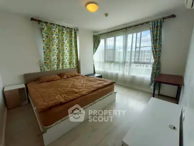 Spacious bedroom with large windows and vibrant curtains in modern apartment