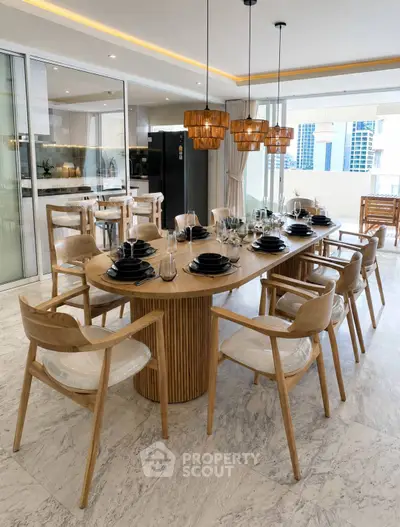 Luxurious dining area with elegant wooden table and chairs, modern lighting, and open kitchen layout.