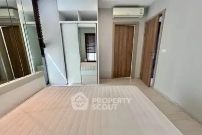 Modern bedroom with mirrored wardrobe and air conditioning in a stylish apartment.