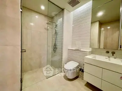 Modern bathroom with glass shower, sleek fixtures, and elegant tile design.