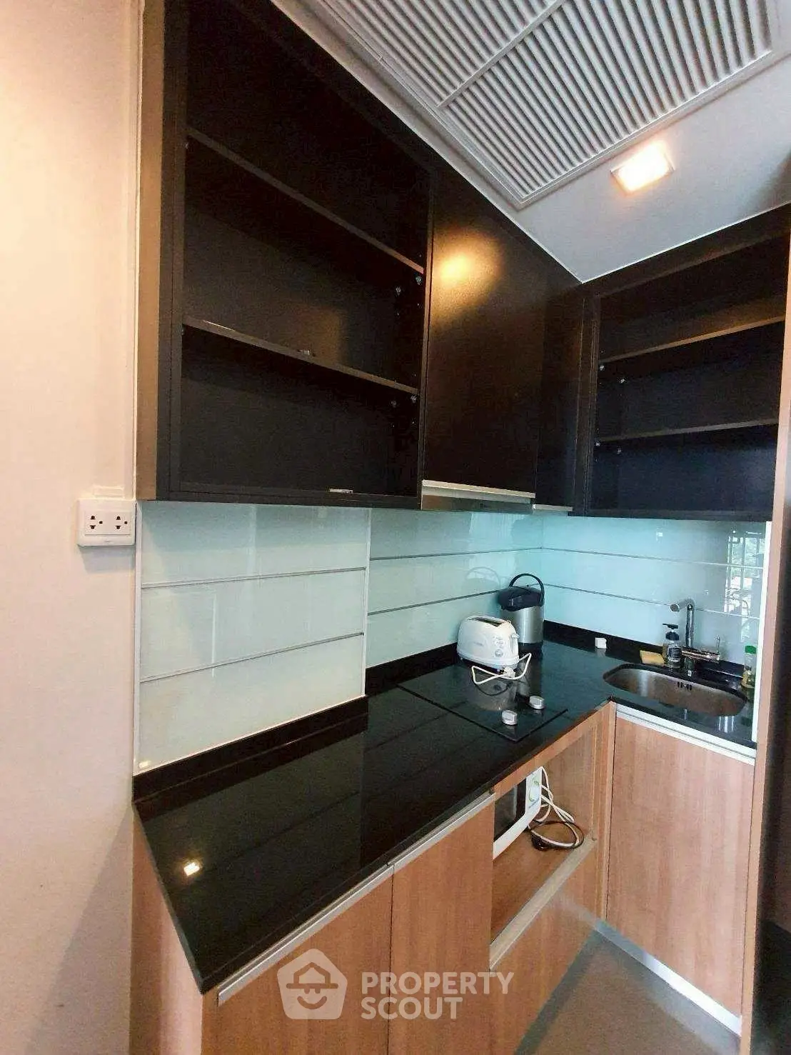 Modern kitchen with sleek black countertops and wooden cabinets