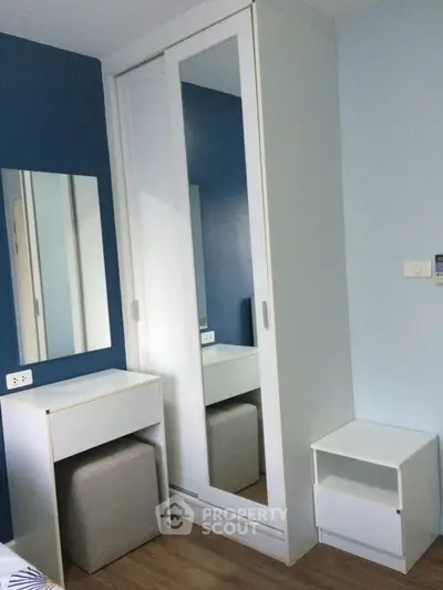 Modern bedroom with sleek mirrored wardrobe and stylish furniture