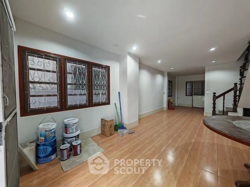Spacious interior with wooden flooring and staircase, ideal for customization.