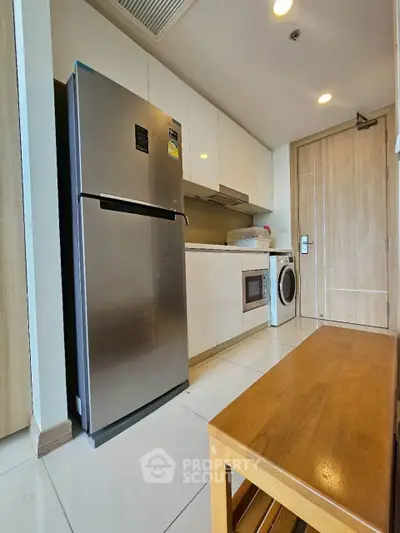 Modern kitchen with stainless steel fridge, washing machine, and wooden bench