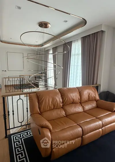 Luxurious living room with modern chandelier and leather sofa