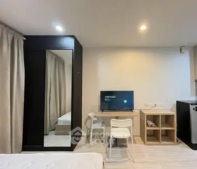 Modern studio apartment with sleek furniture and wall-mounted TV, ideal for urban living.