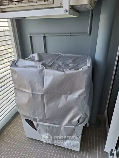 Compact balcony with covered washing machine and city view