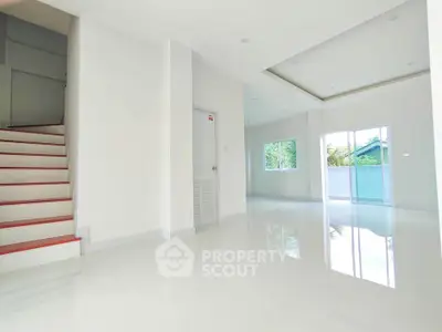 Spacious modern living room with glossy white tiles and large windows