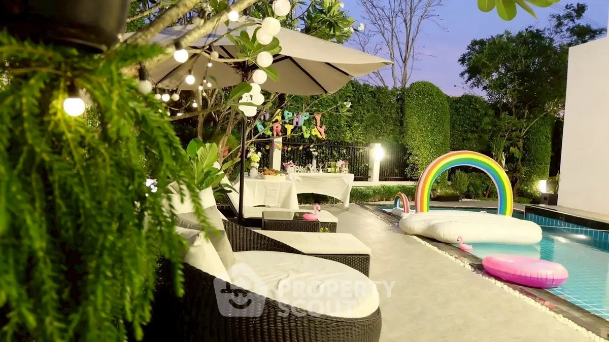 Luxurious poolside area with festive decorations and lush greenery, perfect for entertaining.