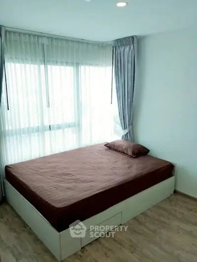 Bright bedroom with large windows and wooden flooring