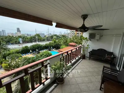Spacious balcony with pool view in urban setting, perfect for relaxation.