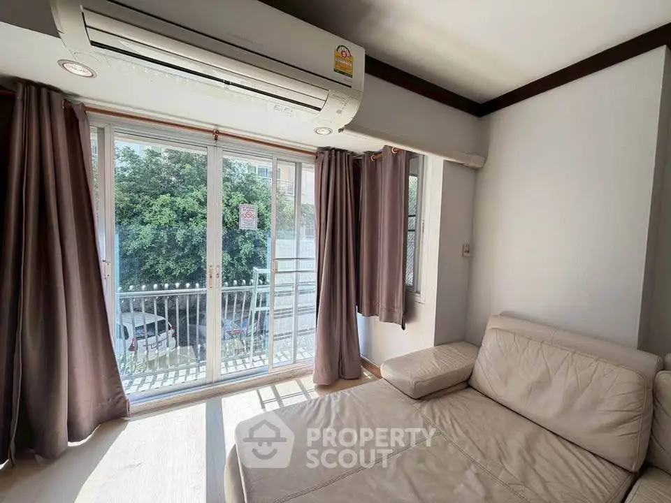 Bright living room with large windows and modern air conditioning unit