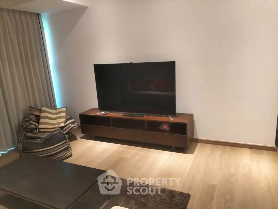 Modern living room with sleek TV setup and cozy seating area.