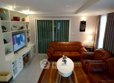 Cozy living room with leather sofas, modern decor, and built-in shelving.