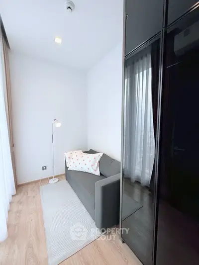 Cozy modern living room with sleek sofa and floor lamp, perfect for relaxation.