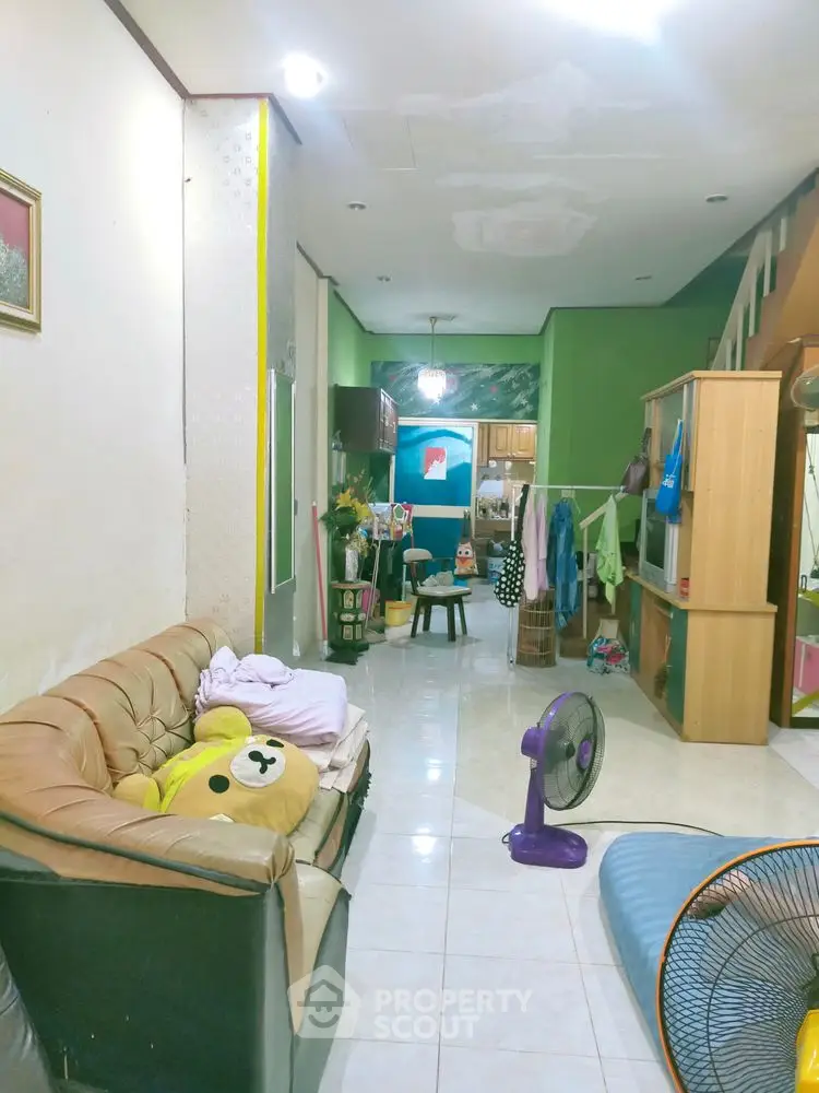 Spacious living room with cozy seating and vibrant green walls, perfect for family gatherings.