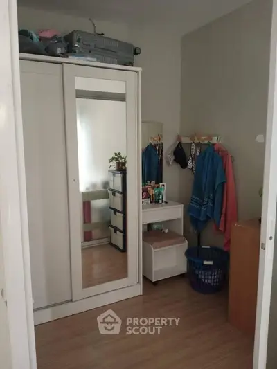 Cozy bedroom with mirrored wardrobe and organized storage space.