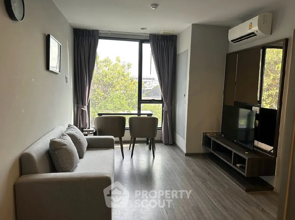 Modern living room with large window and stylish furniture in a cozy apartment.