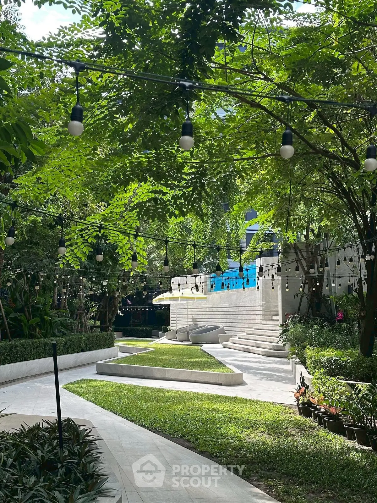 Lush garden with modern landscaping and ambient lighting in a serene residential complex.