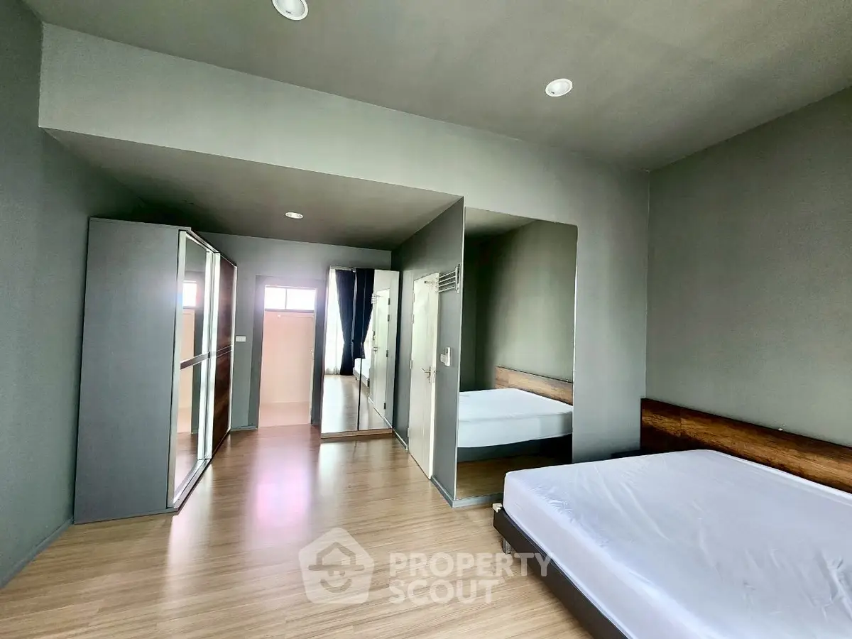 Spacious modern bedroom with minimalist design and large mirrored wardrobe