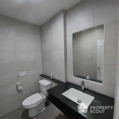 Modern bathroom with sleek black countertop and large mirror